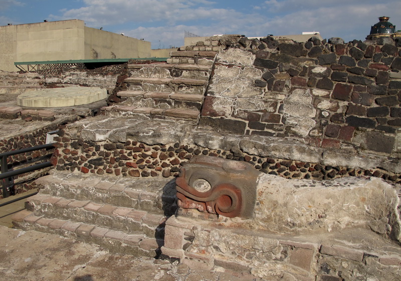 Base de una de las escalinatas del templo Mayor y en la esquina izquierda la copia del monolito que representa a la diosa Coyolxhauqui ubicada donde se encontró la original.