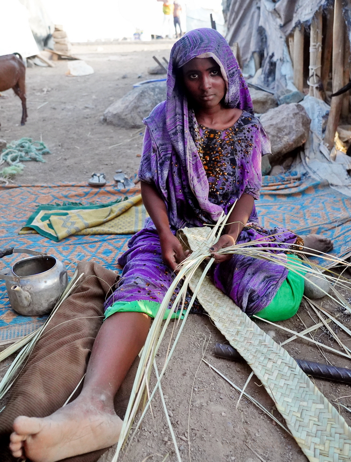 joven afar tejiendo palma